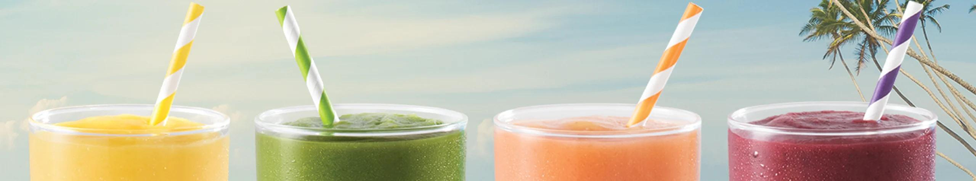 4 glasses of Tropical Smoothie Cafe Smoothies with sky blue background and coconut trees. Mango Magic, Sunrise Sunset, Blueberry Bliss & Green Smoothie